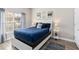 Comfortable bedroom with a queen-size bed, decorative artwork, and natural light at 4891 Clock Tower Dr, Kissimmee, FL 34746