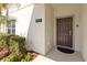 Welcoming front door with a modern address plaque, surrounded by neat landscaping at 4891 Clock Tower Dr, Kissimmee, FL 34746