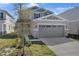 Two-story home with stone accents, a well-manicured lawn, and a two-car garage at 195 Bull Frog Ln, Umatilla, FL 32784