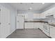 Bright kitchen featuring white appliances, cabinets, and modern gray flooring at 2078 Cypress Bay Blvd, Kissimmee, FL 34743