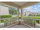 Charming covered porch with white railings, offering a view of a landscaped neighborhood at 2078 Cypress Bay Blvd, Kissimmee, FL 34743
