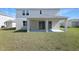 Back yard featuring a covered patio with sliding glass doors and a view of the green lawn at 1496 August Gray Dr, Kissimmee, FL 34744
