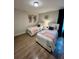 Inviting bedroom showcasing two twin beds with light pink and gray bedding, complemented by contemporary artwork at 1676 Moon Valley Dr, Davenport, FL 33896