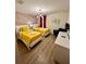 Cheerful bedroom featuring two twin beds with bright yellow bedding, Mickey Mouse wallpaper, and a modern chandelier at 1676 Moon Valley Dr, Davenport, FL 33896