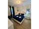Stylish bedroom featuring a blue bed with silver accents, complemented by modern furnishings and natural light at 1676 Moon Valley Dr, Davenport, FL 33896
