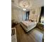 Elegant main bedroom featuring a tufted headboard bed, chandelier, and neutral tones, creating a relaxing retreat at 1676 Moon Valley Dr, Davenport, FL 33896