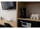 Hotel unit desk and shelves featuring a safe, coffeemaker, and welcome amenities at 5245 W Irlo Bronson Memorial Hwy # 160, Kissimmee, FL 34746