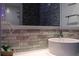 Bathroom featuring a round sink, a large mirror, and brick-like tile accent wall at 5245 W Irlo Bronson Memorial Hwy # 160, Kissimmee, FL 34746