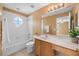 Well-lit bathroom featuring a tub with tile surround and vanity with ample countertop space at 121 Madiera Beach Blvd, Kissimmee, FL 34746