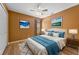 Inviting bedroom with a large bed, wood floors, and two beautiful landscape pictures on the wall at 121 Madiera Beach Blvd, Kissimmee, FL 34746