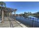 Scenic boardwalk with pergola overlooks the calm lake, enhanced by lush trees and a tranquil neighborhood backdrop at 121 Madiera Beach Blvd, Kissimmee, FL 34746