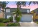 Two-story home featuring a two-car garage, manicured landscaping, and a covered front entry at 121 Madiera Beach Blvd, Kissimmee, FL 34746