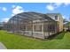 Back exterior showcasing the screened-in pool area and grassy backyard at 121 Madiera Beach Blvd, Kissimmee, FL 34746