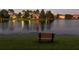 A peaceful evening view of the lake with a bench in the foreground at 121 Madiera Beach Blvd, Kissimmee, FL 34746