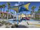 Community playground featuring colorful play structures, shade coverings, and palm trees at 121 Madiera Beach Blvd, Kissimmee, FL 34746