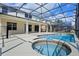 A beautiful screened-in pool with a hot tub is surrounded by a patio and backyard at 121 Madiera Beach Blvd, Kissimmee, FL 34746