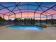 Stunning pool with a sunset view, a lake view, and a screened-in enclosure offering a private oasis at 121 Madiera Beach Blvd, Kissimmee, FL 34746