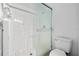 White-tiled shower with a glass door and a low-flow toilet at 1548 Tiverton Blvd, Winter Garden, FL 34787