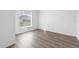 Light-filled bedroom with wood-look floors, a window, and white walls at 1548 Tiverton Blvd, Winter Garden, FL 34787