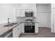 Well-equipped kitchen with stainless steel appliances, granite countertops, and sleek white cabinetry at 1548 Tiverton Blvd, Winter Garden, FL 34787