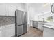 Modern kitchen featuring stainless steel appliances, granite countertops, and white cabinetry at 1548 Tiverton Blvd, Winter Garden, FL 34787