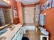 Bathroom boasts a tub shower, double vanity, and beachy decor at 2867 Longleaf Ct, Kissimmee, FL 34746