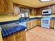 Kitchen boasts wood cabinets, blue tile, and white appliances at 2867 Longleaf Ct, Kissimmee, FL 34746