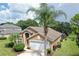 Charming single-story home with attached two car garage, manicured lawn, and tropical landscaping at 1652 Dunes Ct, Haines City, FL 33844
