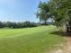 Beautiful view of the green golf course lined with trees on a sunny day at 1652 Dunes Ct, Haines City, FL 33844