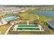 Aerial view of bocce ball courts and a lakeside recreation area with lush lawns and walking paths at 1853 Summer Serenity Dr, Kissimmee, FL 34744