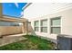 Backyard featuring a covered patio area, a small patch of grass, and the exterior wall of the house with windows at 1853 Summer Serenity Dr, Kissimmee, FL 34744