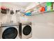 Laundry room with front load washer and dryer set with wire shelving at 1853 Summer Serenity Dr, Kissimmee, FL 34744