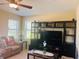 Comfortable living room featuring a ceiling fan, entertainment center, and cozy seating arrangement at 1880 Monte Cristo Ln, Kissimmee, FL 34758