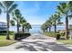 Palm tree-lined driveway leading to a tranquil lake with a dock and boat lift at 267 Spinnaker Ct, Auburndale, FL 33823