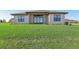 Inviting single-story home featuring a manicured front lawn and a modern facade with dark trimmed windows at 267 Spinnaker Ct, Auburndale, FL 33823