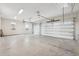 Spacious three-car garage with ample lighting and neutral concrete flooring, ready for your vehicles and storage at 267 Spinnaker Ct, Auburndale, FL 33823