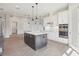 Modern kitchen with granite countertops, gray island, stainless steel appliances, and custom cabinets at 267 Spinnaker Ct, Auburndale, FL 33823