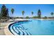Beautiful community pool with clear water, palm trees, and ample seating for residents at 267 Spinnaker Ct, Auburndale, FL 33823
