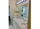 Bright bathroom featuring a double sink vanity with light countertop and large mirror with Hollywood style lighting at 319 Celebration Blvd, Celebration, FL 34747