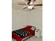 Small cozy bedroom with a ceiling fan and light, carpet and a single bed with red and black bedding at 319 Celebration Blvd, Celebration, FL 34747