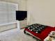 Cozy bedroom with carpet, a window with blinds, and a small television with a chest of drawers at 319 Celebration Blvd, Celebration, FL 34747
