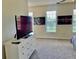 Bedroom featuring a dresser, TV, and two windows at 319 Celebration Blvd, Celebration, FL 34747