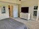 Comfortable bedroom features a large bed, dresser with a TV, and an ensuite bathroom at 319 Celebration Blvd, Celebration, FL 34747