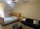 Bedroom with sloped ceilings includes a full sized bed, sofa, glass top coffee table, and ceiling fan at 319 Celebration Blvd, Celebration, FL 34747