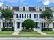 Charming townhouse with well-manicured lawn, dormer windows, black shutters, and a symmetrical facade at 319 Celebration Blvd, Celebration, FL 34747