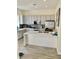 A modern kitchen with gray cabinets, a large island with a white countertop, and tile flooring at 319 Celebration Blvd, Celebration, FL 34747