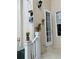 Outdoor patio area featuring wall mounted planters, railing with potted plant, exterior door with light, and air conditioner at 319 Celebration Blvd, Celebration, FL 34747