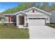 Charming single-Gathering home featuring a two-car garage and appealing curb appeal with a landscaped front yard at 4235 Sawtooth Ct, Tavares, FL 32778
