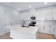 Modern kitchen featuring white cabinetry, stainless steel appliances, and a large kitchen island at 4235 Sawtooth Ct, Tavares, FL 32778