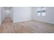 Bright living room featuring wood floors, white walls, and access to the hallway and access to the backyard at 4235 Sawtooth Ct, Tavares, FL 32778